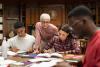 A lecturer observes her students reading