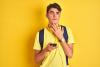 Young male student looking perplexed with mobile phone