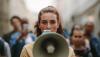 A woman holds a megaphone at a protest