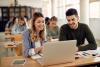 Two students working on a laptop together