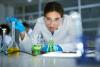 A scientist drops liquid into a beaker