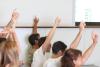 Students with their hands up in class