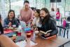 Students chatting together at a table in class