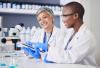 Two female scientists consulting a document in a lab 