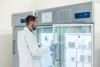 A scientist opens a freezer in a lab