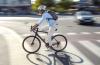 A cyclist riding down a quiet city road