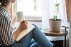 Woman writing in journal by window