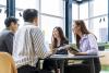 Students and mentors laugh around a table