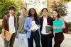 A group of smiling students standing outside on university campus grounds
