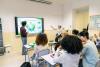University students having a discussion about climate change while one presents a poster titled "Save the planet"