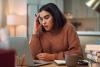 Young female student looking confused at laptop