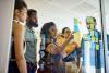 Staff and students strategising with Post-It notes on a transparnt screen